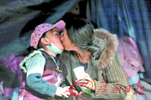 在玉樹州人民醫(yī)院的帳篷里，扎西永措沖好藥后用嘴給感冒的女兒喂藥。 記者龍成通 攝