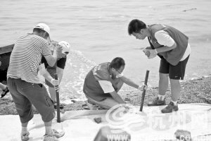 大連市黑石礁，志愿者試圖阻攔油污。