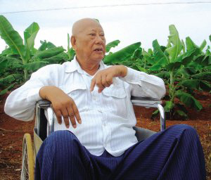 陳光保在自己的農(nóng)場(chǎng)里，他身后就是一片香蕉林(中青報(bào)蔣昕捷供圖)