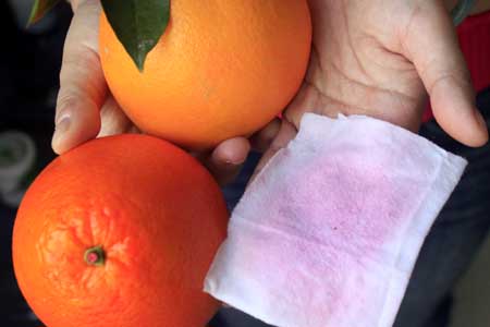 染了色的橙子（下）顏色明顯更深，用紙一擦就褪色