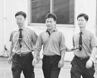 圖為陳建學(xué)被押送接受審訊。吳曉鋒攝